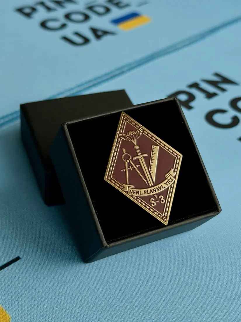 золотий пін-ромб у подарунковій коробочці